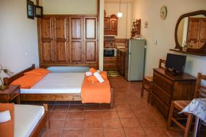 a bedroom with a bed with orange pillows on it at erofili apartments in Kalamos