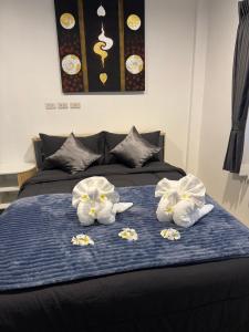 Ban Nong ChaengにあるPattiya Houseのベッドにタオル2枚(花付)
