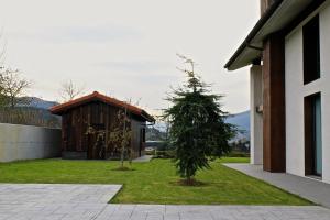 un pequeño árbol en un patio al lado de un edificio en Casa Rural Kutxatxuri, en Aracaldo