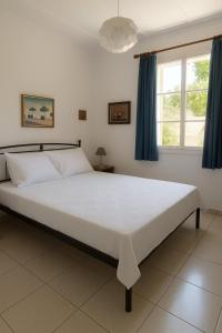 a bedroom with a large white bed with blue curtains at Traditional Family House in Grizáta