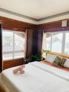 a bedroom with a bed with a pink towel on it at Dalat Note Hostel in Da Lat
