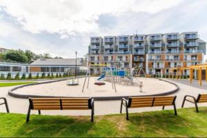 a park with a playground in front of a building at SEA & SMILE APARTMENT - BASEN, SAUNA, PARKING, WIFI, SPA Kołobrzeg Podczele in Kołobrzeg