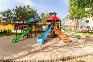 a playground with two slides and a play structure at SEA & SMILE APARTMENT - BASEN, SAUNA, PARKING, WIFI, SPA Kołobrzeg Podczele in Kołobrzeg