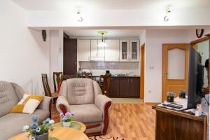 a living room with a couch and chairs and a kitchen at Gradina Stan na Dan in Doboj