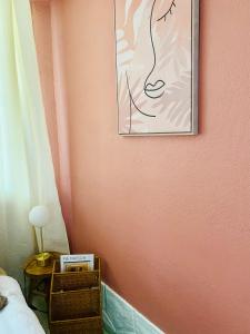 a bedroom with a pink wall with a picture on the wall at Les jardins de Phidji in Buzet-sur-Tarn +24 photos