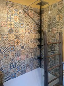 a bathroom with a wall covered in tiles at Les jardins de Phidji avec entrée autonome climatisation neuve et parking privé in Buzet-sur-Tarn +19 photos