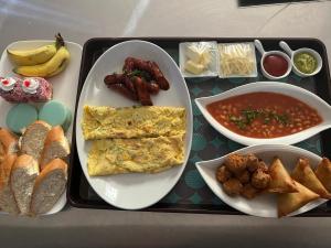 a tray of breakfast food with eggs sausage and beans at Honey studio in Rivière Noire +7 photos