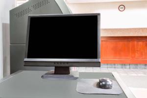 a computer monitor and a mouse on a desk at Ramada Limited Norfolk in Greenwich +11 photos