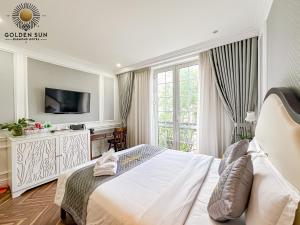 a white bedroom with a bed and a tv at Diamond Boutique Hotel - Phú Mỹ Hưng in Ho Chi Minh City