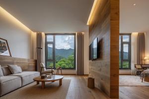 un salon avec un canapé et une table dans l'établissement Yunfu Mid Hill Resort Hote, à Honghuaping