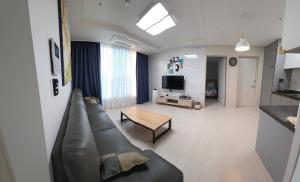 a living room with a couch and a table at Nangman Yeosu in Yeosu