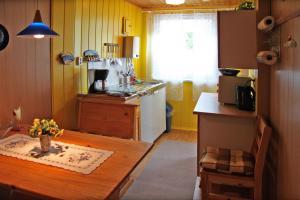 a kitchen with a wooden table and a kitchen with yellow walls at Unterkünfte in Zarrendorf in Zarrendorf