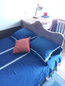 a bed with blue pillows and a table with a lamp at apartmtnt near Victori Squaue in Kyiv