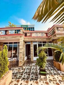 a building with a palm tree in front of it at Kigali great homes in Kigali