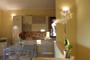 a kitchen with a table and a vase with white flowers at Villa Antares in Custonaci