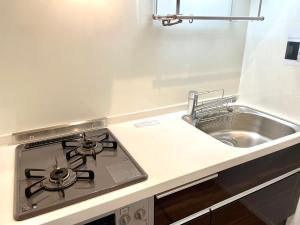 a stove top oven in a kitchen next to a sink at EveryNet Shinjuku by Tranova in Tokyo