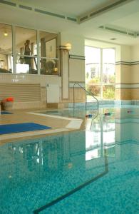 a large swimming pool with water in a building at Penmere Manor Hotel in Falmouth