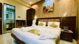 a bedroom with a large bed with white flowers on it at THE CLAN HOTEL - VIJAY NAGAR Indore in Indore