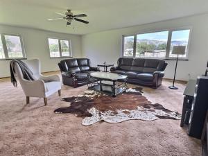 a living room with leather furniture and a table at Herrera Estate Private Two-Home Retreat in Keremeos