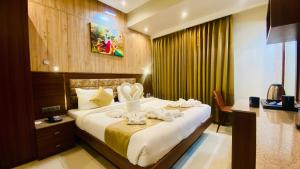 インドールにあるTHE CLAN HOTEL - VIJAY NAGAR Indoreのタオルが敷かれた大きなベッドのある寝室