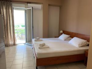 a bedroom with a bed with two towels on it at Hotel Aki in Loutra Edipsou