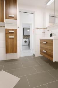 a kitchen with white and wood cabinets and a sink at LETA Homes - Komfortables Gästehaus - eigene Parkplätze & Traumterrasse in Straubing
