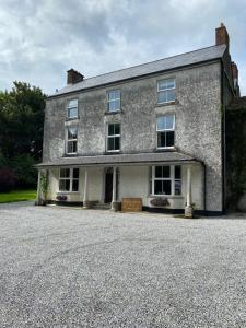an old stone house with a large driveway at Farnagh House - En Suite Bedrooms in Moate