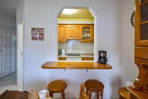 a kitchen with a counter and some wooden cabinets at CasitaRino in Puerto de Santiago +21 photos