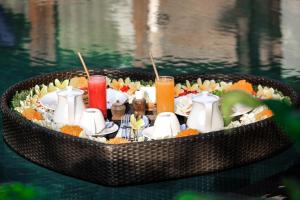 a tray of food on a table in the water at Yana Villas Kemenuh by GenuineHost in Ubud