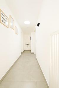 a hallway with white walls and a tile floor at LETA Homes - Komfortables Gästehaus - eigene Parkplätze & Traumterrasse in Straubing +22 photos