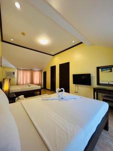 a bedroom with a large bed with a swan on it at Sheridan Villas Boracay in Boracay