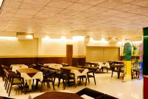 印多尔THE CLAN HOTEL - VIJAY NAGAR Indore的用餐室配有桌椅