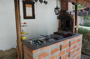 a kitchen with a brick oven and a sink at Къщи "И пак дойдох" in Tryavna