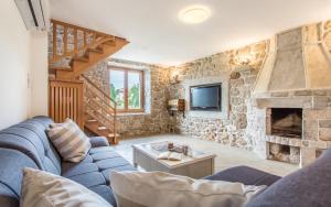 クリムノにあるVilla Klimnoの青いソファと石壁のリビングルーム