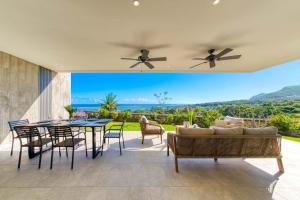 a patio with a couch and a table and chairs at Domaine d'Anbalaba - Baie du Cap - Ile Maurice in Baie du Cap