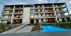 an apartment building with a swimming pool in front of it at Kierunek Bieszczady in Lesko +15 photos
