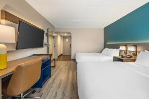 a hotel room with two beds and a flat screen tv at Comfort Inn & Suites Cookeville in Cookeville