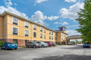 a large building with cars parked in a parking lot at Sleep Inn & Suites Milwaukee Airport in Milwaukee