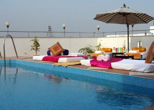 a row of beds sitting next to a swimming pool at The Oasis in Vadodara