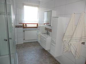 a white bathroom with a sink and a window at Ferienhaus Königreich - Dreistegen in Monschau +20 photos