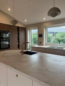a kitchen with a large marble counter top at Topmoderne og bynær villa in Holstebro +14 photos