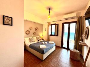 a bedroom with a bed and a large window at Magic estate in the wave 2 in Kótronas