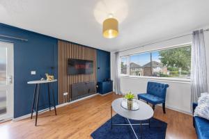a living room with a blue accent wall at 2 Bedroom Modern house in Rainham