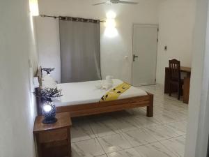 ein Schlafzimmer mit einem Bett und einem Spiegel in einem Zimmer in der Unterkunft Summer Dreams in Nosy Be