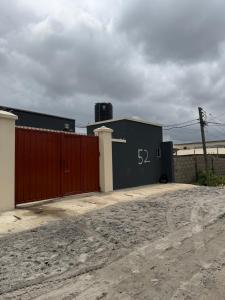 a building with a red gate and a fence at Comfortable Studio apartment in ogudu by Magnanimous apartments in Lagos
