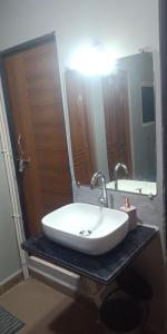 a bathroom with a white sink and a mirror at Shatayu home stay in Ujjain