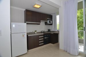 a kitchen with brown cabinets and a white refrigerator at My Apart in Buenos Aires