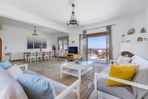 a living room with a couch and a table at Villa Margini, Aegean Views , Pool Villa, Skopelos in Skopelos Town