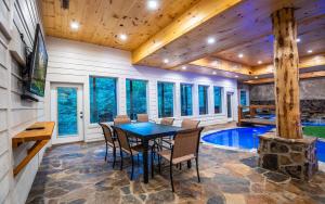 ein Esszimmer mit einem Tisch und Stühlen sowie einem Pool in der Unterkunft Treehouse River Lodge in Pigeon Forge