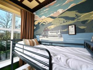 a bedroom with a bed with a ship painted on the wall at YHA Windermere in Troutbeck